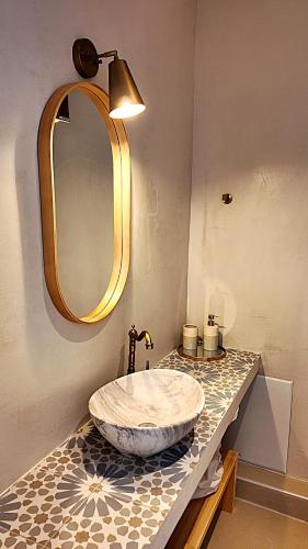 a bathroom with a sink and a mirror on a counter at To Nisaki in Loutraki