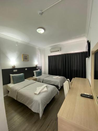a hotel room with two beds and a table at Reis Maris Hotel in Marmaris