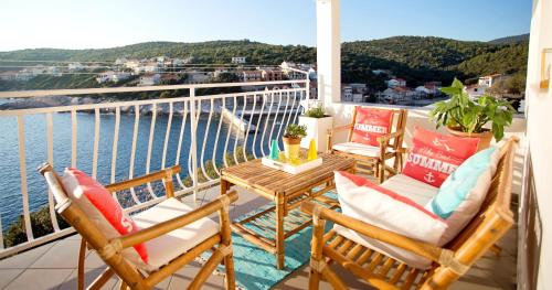 einen Balkon mit Stühlen, einem Tisch und Blick auf das Wasser in der Unterkunft Apartments MT Residence in Zavalatica