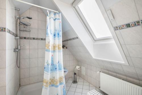 a bathroom with a shower with a shower curtain at Ferienwohnungen zur Eule - Steinkauz in Clausdorf