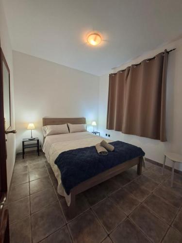 a bedroom with a bed with a blue blanket at APARTAMENTO SOL PLAYA in Punta Mujeres