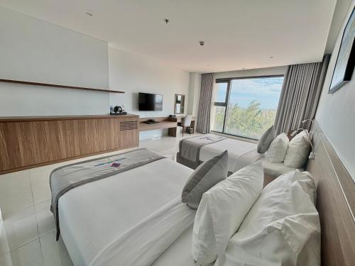 a hotel room with two beds and a television at Long Thuan Hotel & Resort in Phan Rang–Tháp Chàm