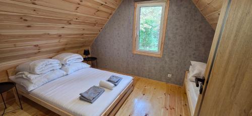 a bedroom with a bed in a wooden house at Leśne Zacisze 4 in Łuka