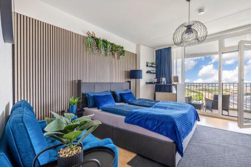 a bedroom with a blue bed and a blue couch at Global Bnb - Loft 28 Blue in Augsburg