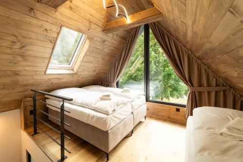 a bedroom with a bed in a room with a window at Chalet - AQUA MARIA RESORT in Veľaty