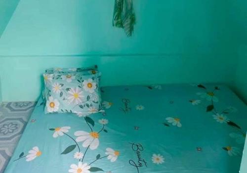 a bed with a blue comforter with flowers on it at Monique Beach Resort by Hiverooms in Carmen