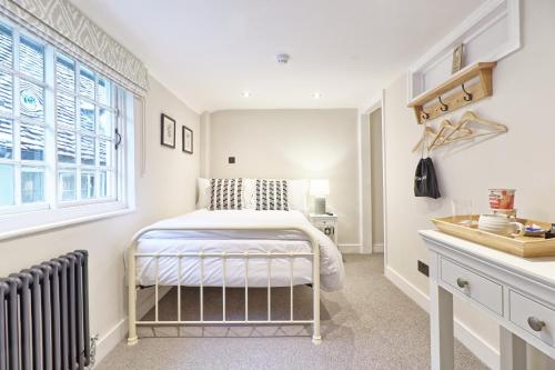 a bedroom with a bed and a window at Noble Goose Rooms in Coggeshall