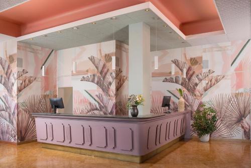 a waiting room with a mirror and a purple counter at NH Ancona in Ancona