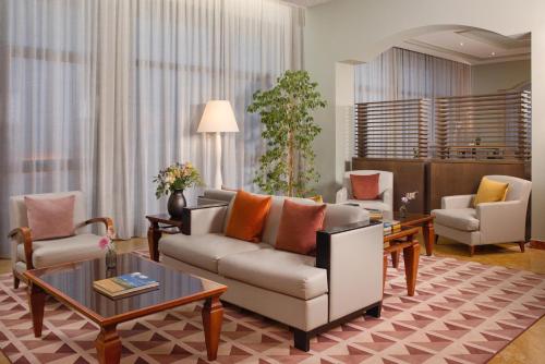 a living room with a couch and two chairs at NH Ancona in Ancona