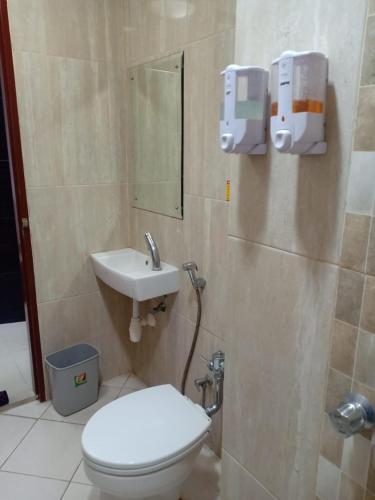 a bathroom with a toilet and a sink at De La Charis Hotel in Kediri