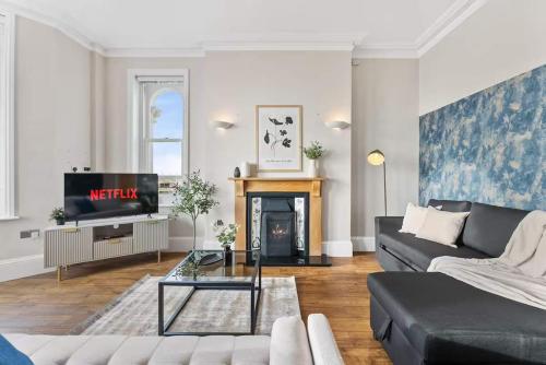a living room with a couch and a fireplace at Seafront Duplex Worthing Beach - Sea Views 8 Guests in Worthing