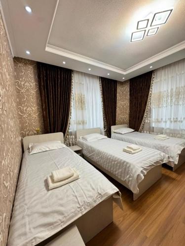 a bedroom with two beds with towels on them at Uya Nest Osh in Osh