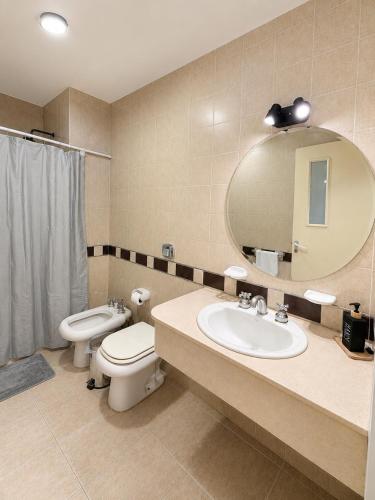 a bathroom with a sink and a toilet and a mirror at Paramont Rosario 4 in Rosario de la Frontera