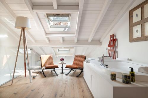 a bathroom with two chairs and a bath tub at Conte Manfredo and Donna Angelina Apartments with Breathtaking Arena Views in Verona in Verona