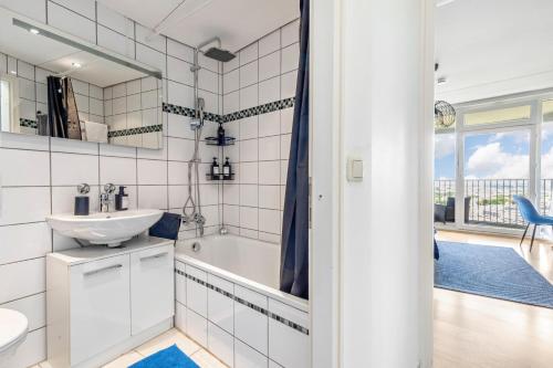 a white bathroom with a sink and a tub at Global Bnb - Loft 28 Blue in Augsburg