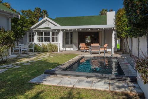 a pool in the yard of a house at Cosy Cottage Onrus - With Pool in Hermanus