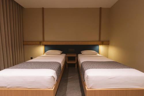 two beds in a small room with twothirdsessions at Legong Keraton Beach Hotel in Canggu