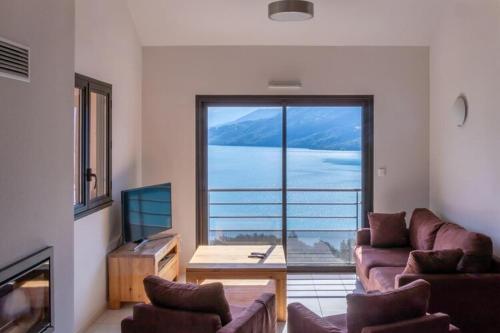 a living room with a large window with a view at Mobile homes for 4 people with lake view in Residence L'Ecrin du Lac, Chorges in Chorges