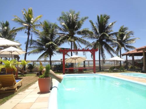 a person is reaching into a swimming pool at Pousada Terceiro Espaço in Guaibim
