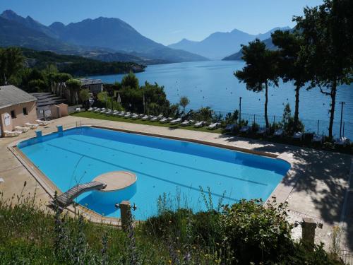 a swimming pool with a view of a lake at Mobile homes for 4 people with lake view in Residence L'Ecrin du Lac, Chorges in Chorges
