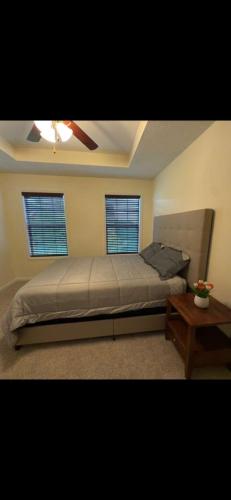 a bedroom with a bed and two windows at Joykip's place in West Des Moines