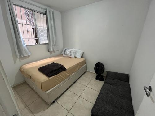 a small bedroom with a bed and a window at Excellent value for money - Fully equipped apartment in Macaé
