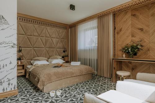 a bedroom with a large bed with a large headboard at Willa Regina I Resort & SPA in Zakopane