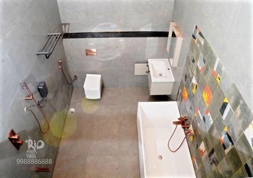 a bathroom with a toilet and a sink at RIO POOL VILLAS in Chīrāla
