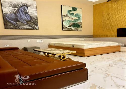 a room with a bed and a couch and a table at RIO POOL VILLAS in Chīrāla