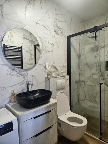 a bathroom with a sink and a toilet and a mirror at Apartments Lorena Mljet in Pomena