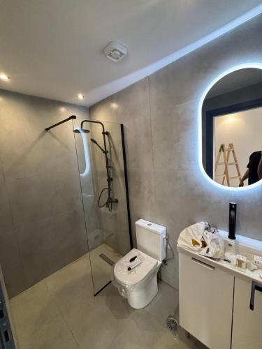 a bathroom with a shower and a toilet and a sink at Angelica Suites Keramoti Area in Keramoti