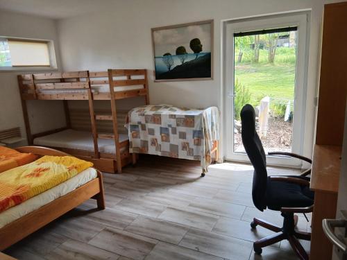 a bedroom with a bed and a desk and a chair at Bungalov v Krásné Lípě in Krásná Lípa