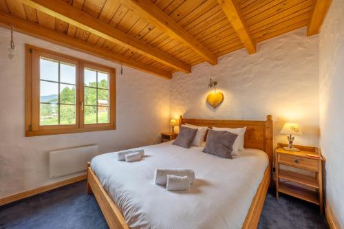 a bedroom with a large bed and a window at Chalet Pierre Blanche in Nendaz