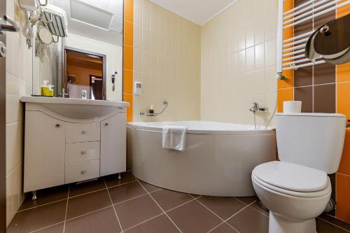 a bathroom with a tub and a toilet and a sink at INTER BUSINESS Bucharest in Bucharest