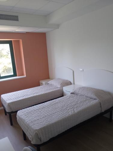 a room with two beds and a window at Viva Campus di GM Industries srl in Ferrazzano