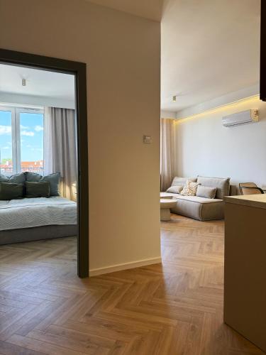 a living room with a couch and a mirror at Kresowy View Apartment in Biłgoraj