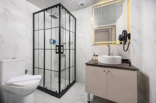 a white bathroom with a toilet and a sink at Taksim Peradise Hotel in Istanbul
