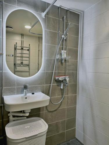 a bathroom with a toilet and a sink and a mirror at 1BR Demure Design & Urban Living in Kamppi in Helsinki