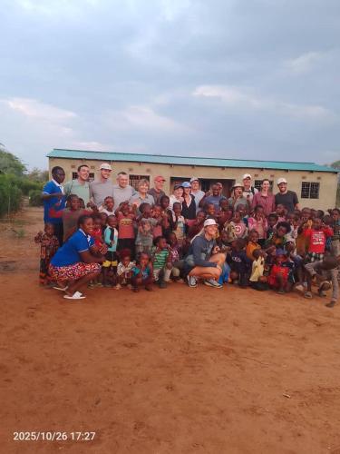 a group of people posing for a picture in front of a truck at Muke Village Guest House in Livingstone