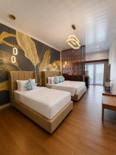 a bedroom with two beds and a wall with a mural at MAHAMAYA Gili Meno in Gili Meno