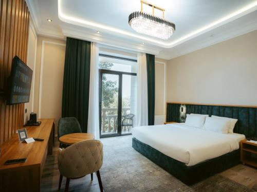 a hotel room with a large bed and a desk and a desk at Baden-Baden Hotel Tashkent in Tashkent