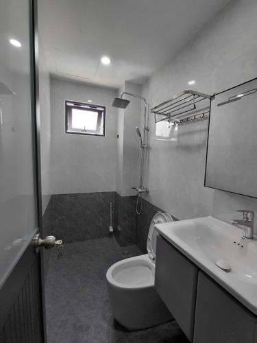a bathroom with a white toilet and a sink at ZENITH STAY by Lan's in Danang