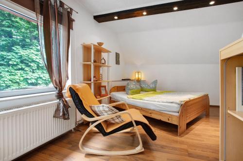 a bedroom with a bed and a chair and a window at Ferienwohnung Hundefreundlich 70 qm in Barth