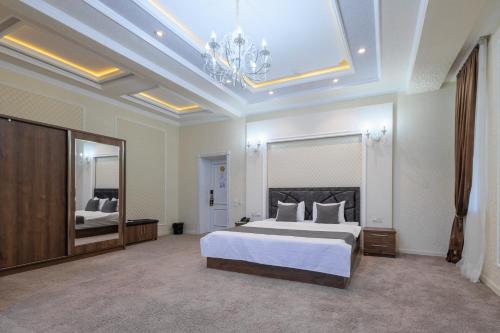 a large bedroom with a bed and a mirror at Merhaba Hotel, Fergana in Fergana