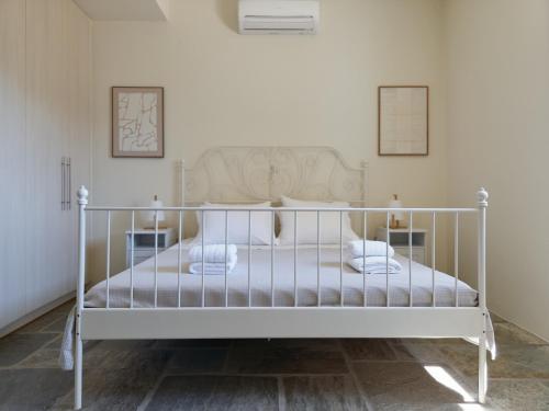 a white bed in a room with two pictures on the wall at Sea Breeze in Otziás