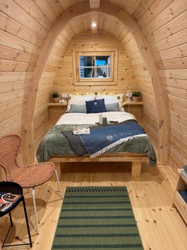 a bedroom with a bed in a wooden cabin at Camp Diekirch - Camping Pod in Gilsdorf
