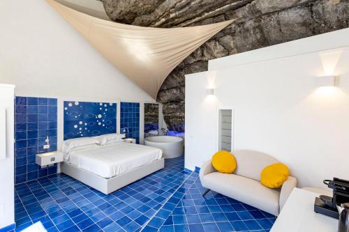 a blue and white bedroom with a bed and a tub at Le Suite dei Pescatori in Praiano