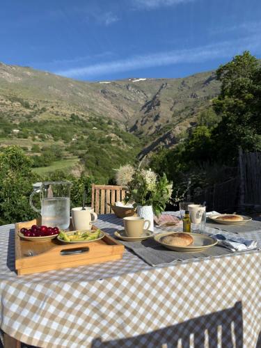 a table with plates of food on it with a view at El Carpintero in Trevélez