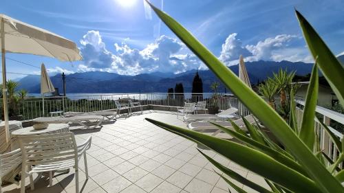 a patio with chairs and tables and a view of the water at La Pervinca Apartments in Malcesine