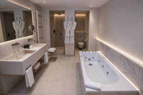 a bathroom with two sinks and a bath tub at Droushia Heights Hotel in Drousha